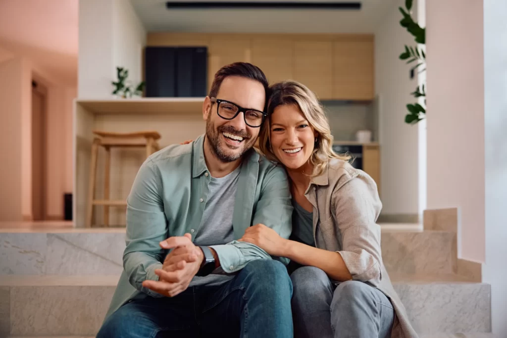 smiling couple relaxing on the stairs at home utc